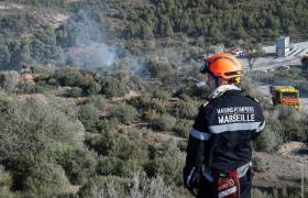 Un marin-pompier de Marseille surveille un massif forestier sur la commune de Marseille pendant une intervention.