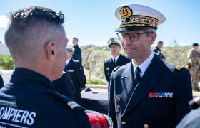 L'amiral remet un casque à un marin-pompier de spécialité "sécurité"